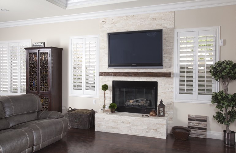 White plantation shutters in a St. George living room with plank hardwood floors.